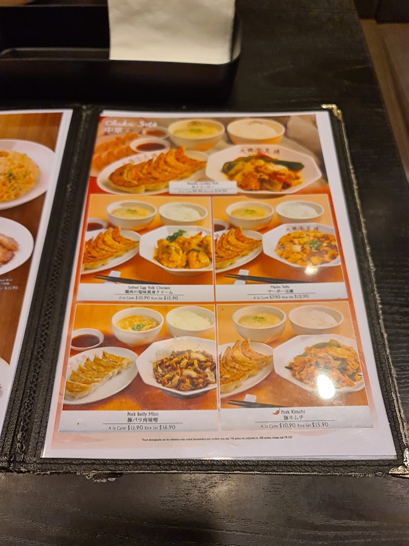 A close-up of a menu page featuring various Japanese and Chinese set meals with images and prices.