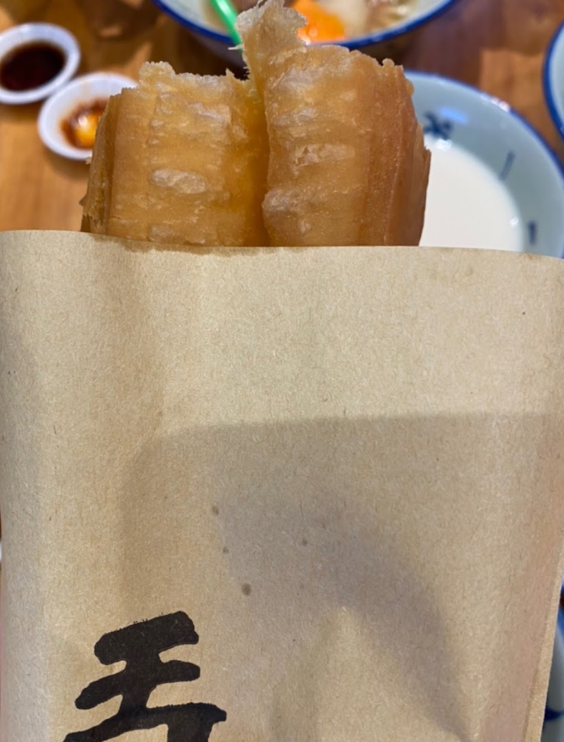 Golden fried dough sticks (youtiao) served in a paper bag from Alley Wei.
