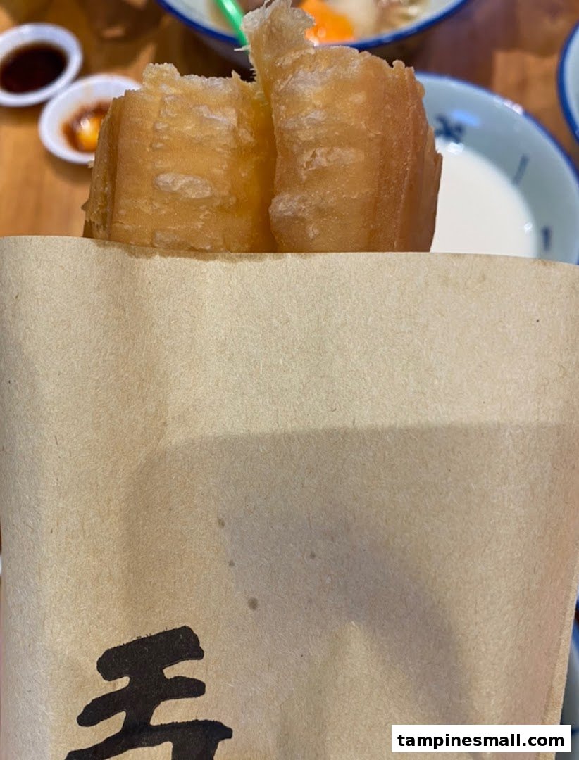 Golden fried dough sticks (youtiao) served in a paper bag from Alley Wei.