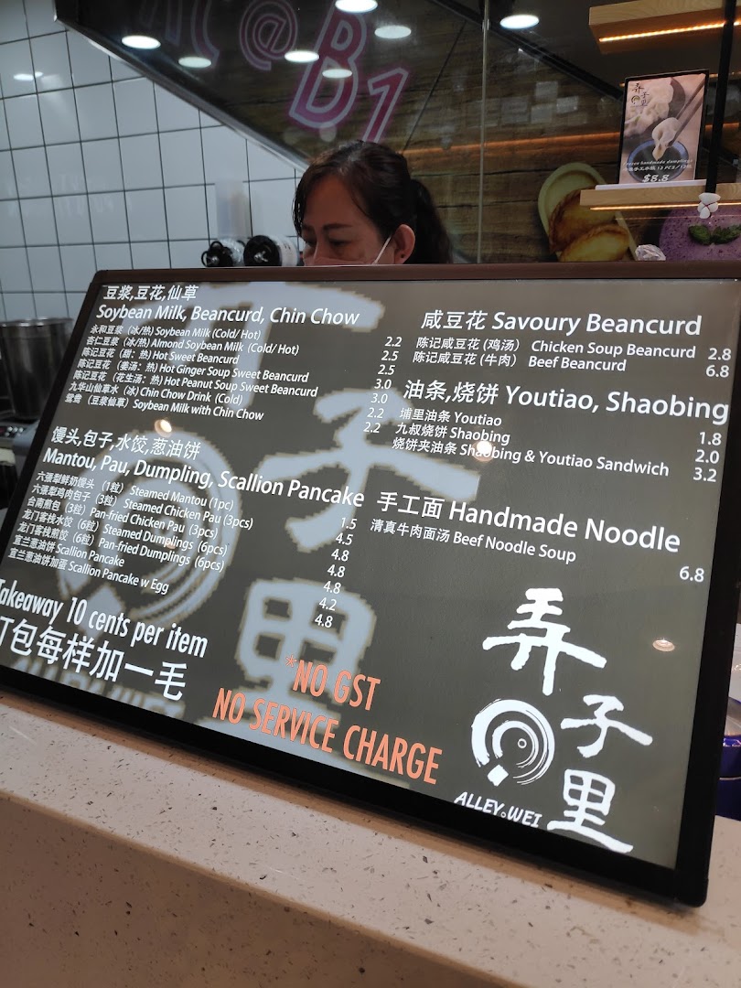 A close-up of a digital menu board displaying traditional Chinese food and drink options at Alley Wei.