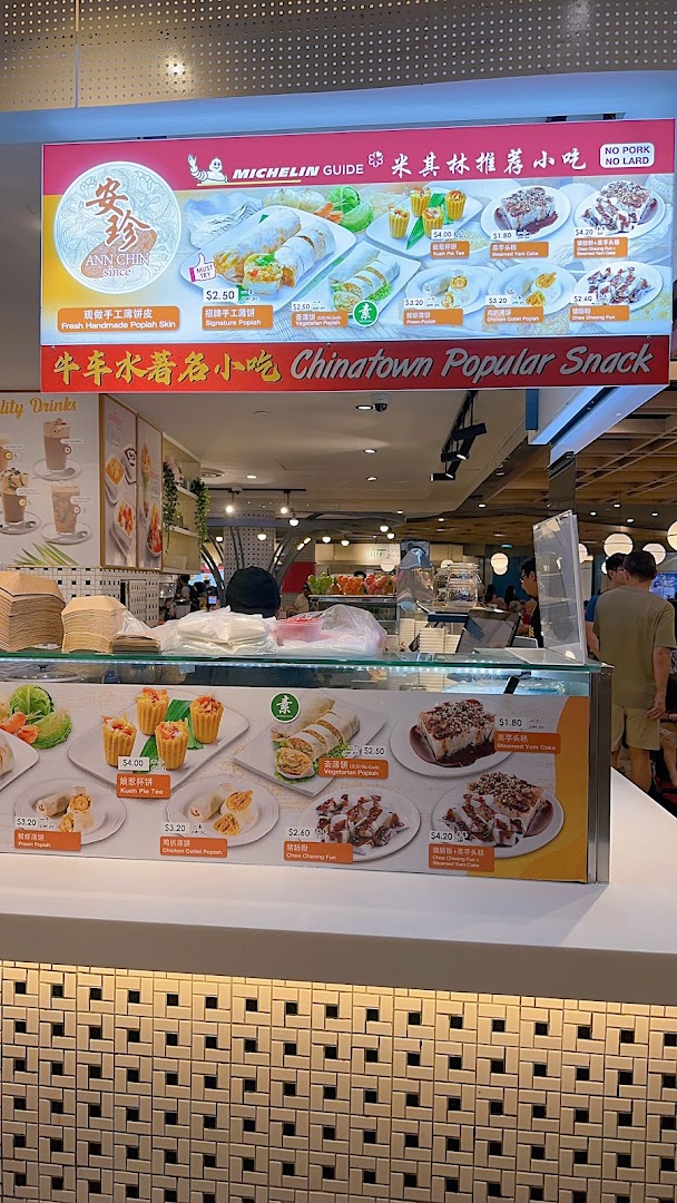 A vibrant menu board and counter display showcasing Ann Chin Popiah's Michelin-recommended snacks.