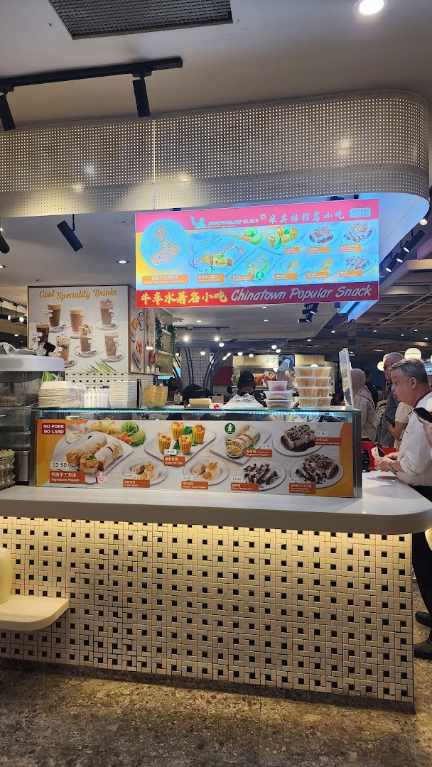 A vibrant food stall counter showcasing a variety of traditional snacks and drinks with overhead menu displays.