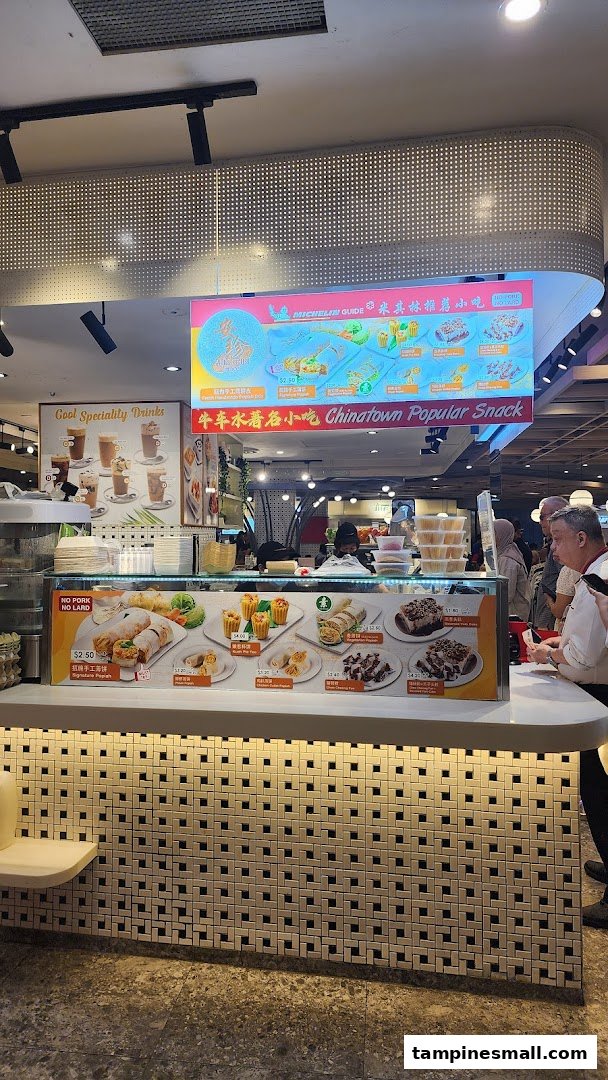 A vibrant food stall counter showcasing a variety of traditional snacks and drinks with overhead menu displays.