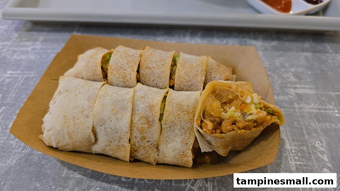 Freshly prepared popiah rolls, sliced and served in a brown paper tray, with one roll showing its delicious filling.