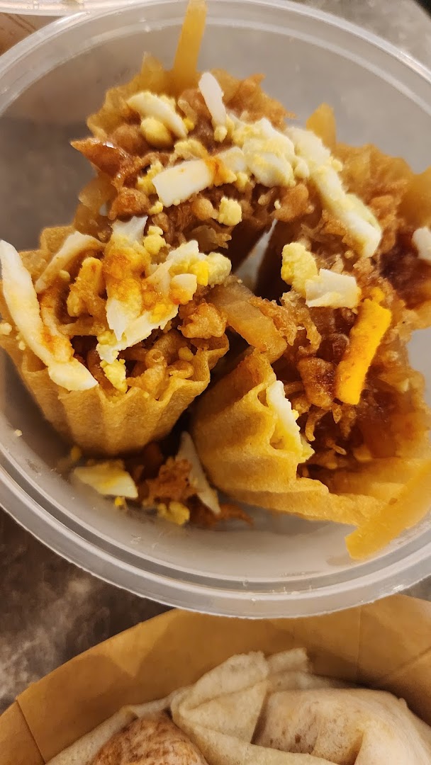 A close-up of several crispy golden tart shells filled with savory ingredients and topped with chopped egg.