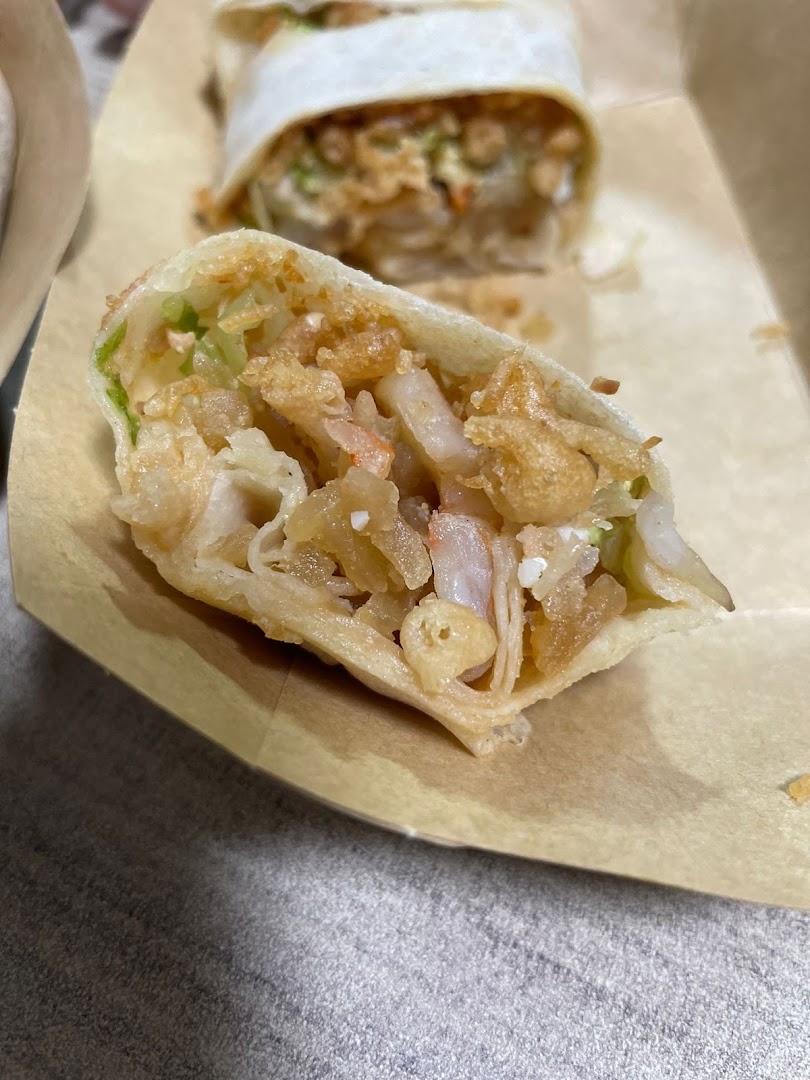 A close-up of a freshly cut popiah revealing its delicious fillings.