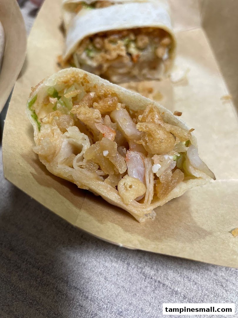 A close-up of a freshly cut popiah revealing its delicious fillings.