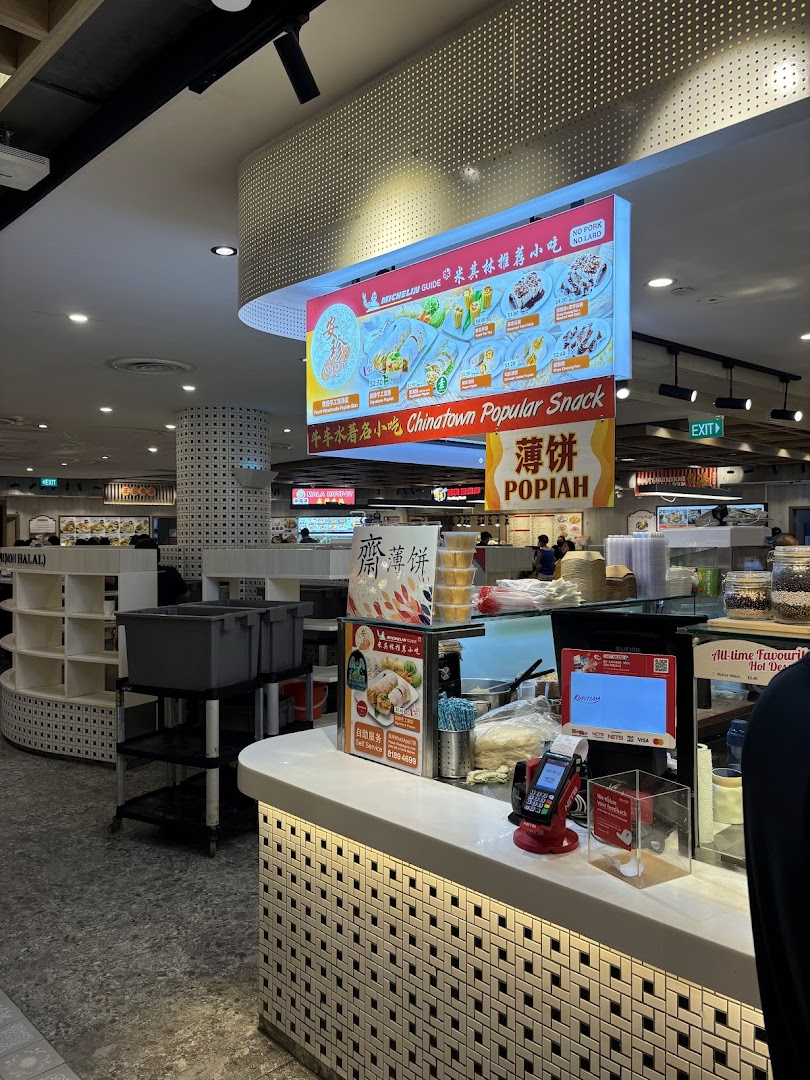 An overhead digital menu board displaying various popiah and traditional hot desserts with prices.