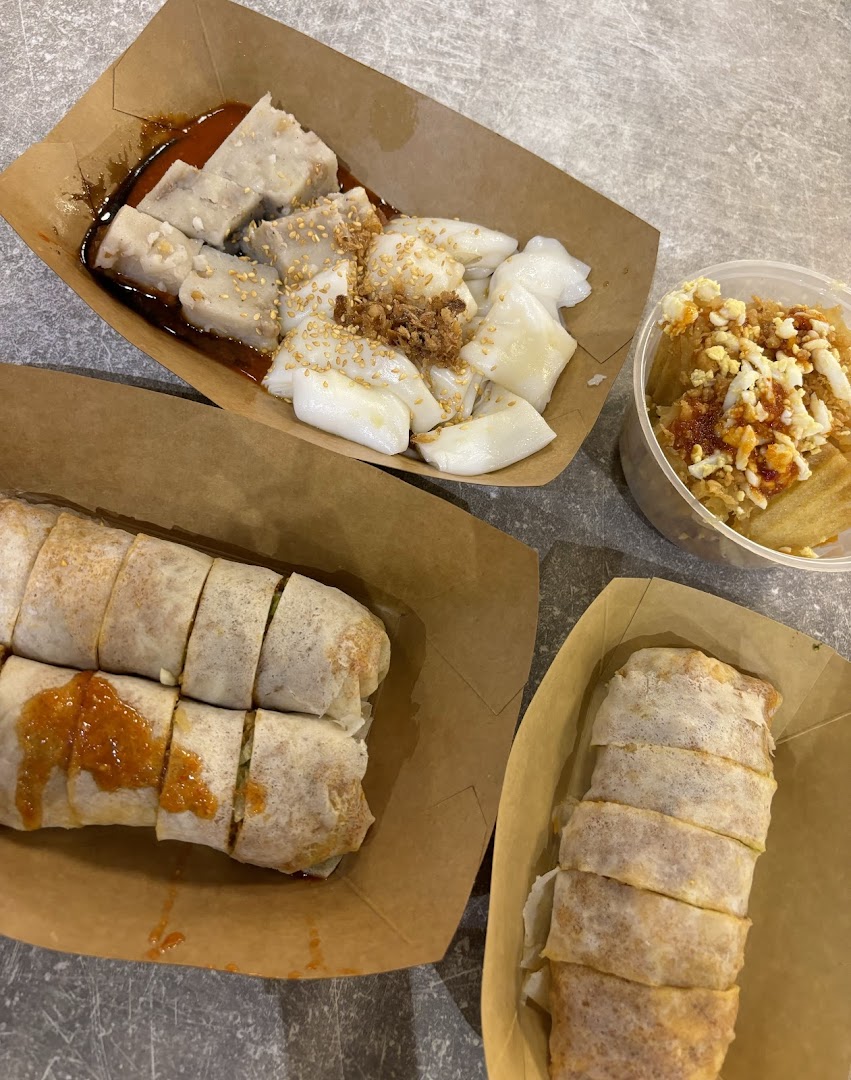A spread of delicious Ann Chin Popiah, yam cake, and chee cheong fun in takeaway containers.