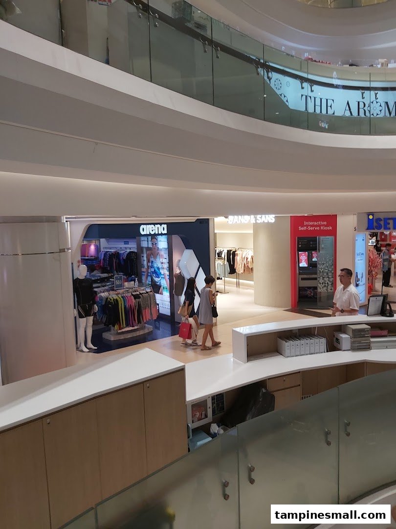 View of the Arena shop entrance in a multi-level shopping mall, showcasing swimwear and activewear.