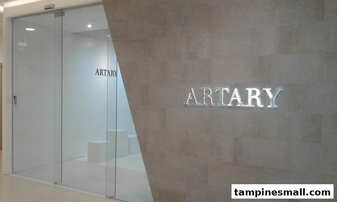 The modern glass and stone entrance of ARTARY, an art education center, with its illuminated logo.