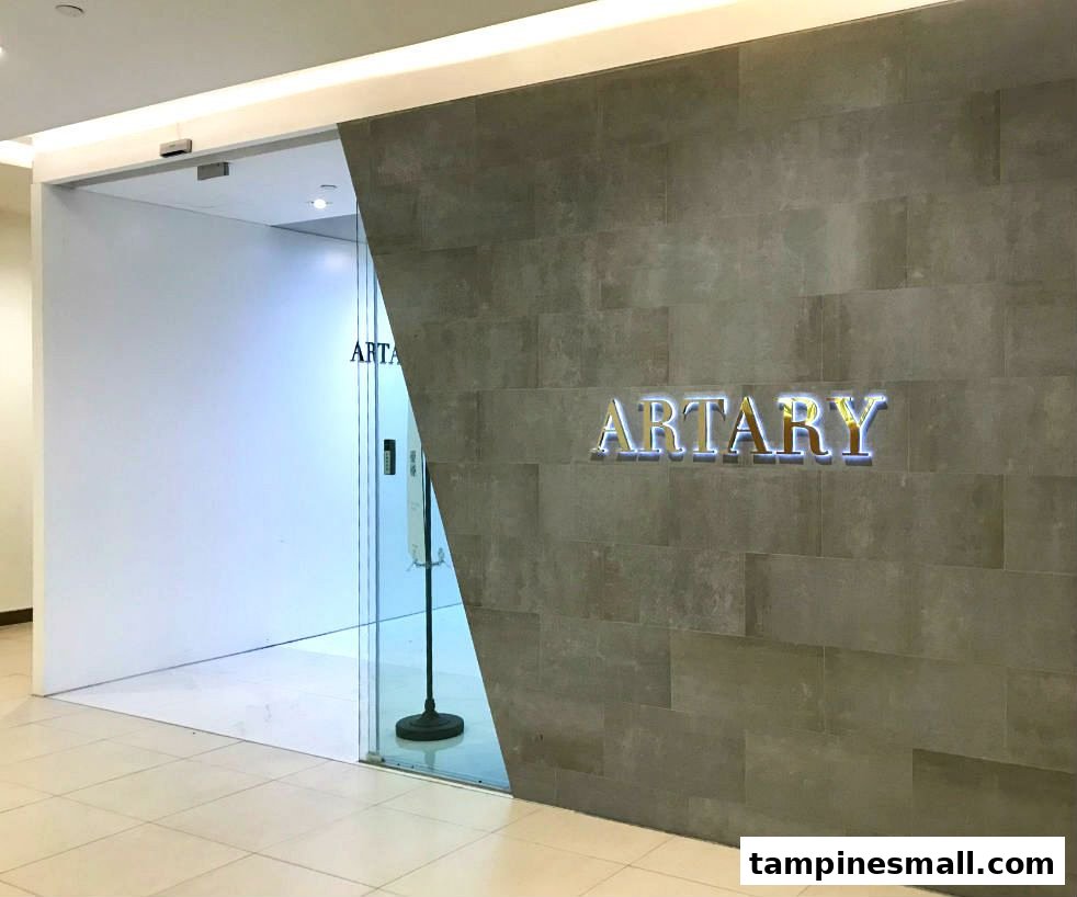 The modern entrance of ARTARY, featuring a glass door and a textured wall with the illuminated shop name.