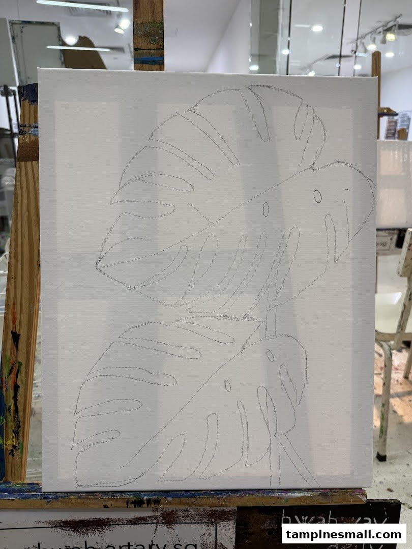 A white canvas on an easel with a pencil outline of monstera leaves, ready for painting.