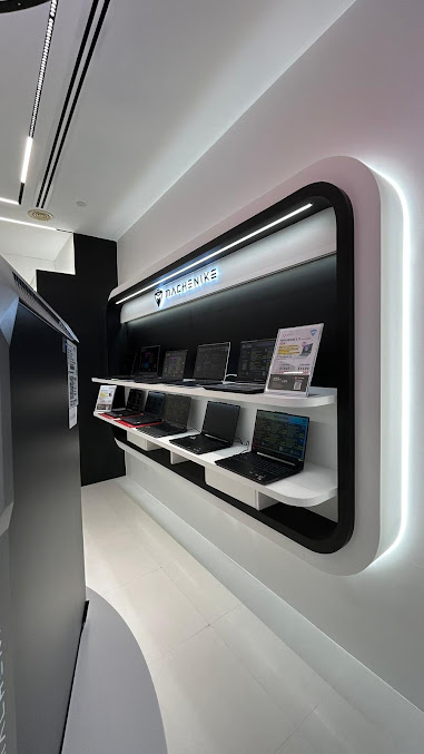 A modern display of various laptops from MACHENIKE in a retail store.