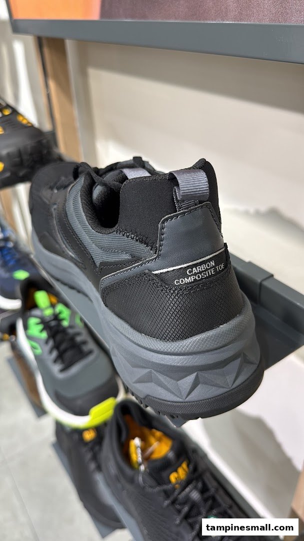 Close-up of a black and grey work shoe with 'CARBON COMPOSITE TOE' on display in a retail store.