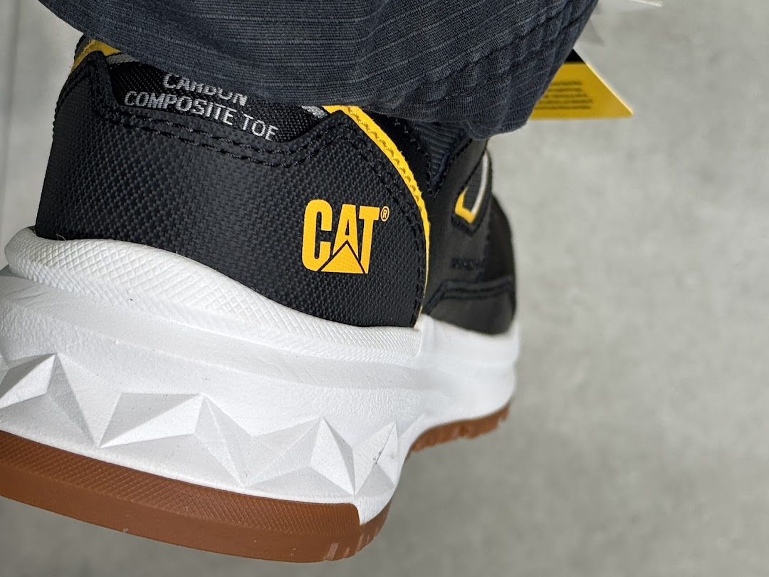 Close-up of a black and yellow CAT brand shoe with a white sole and 'COMPOSITE TOE' text.