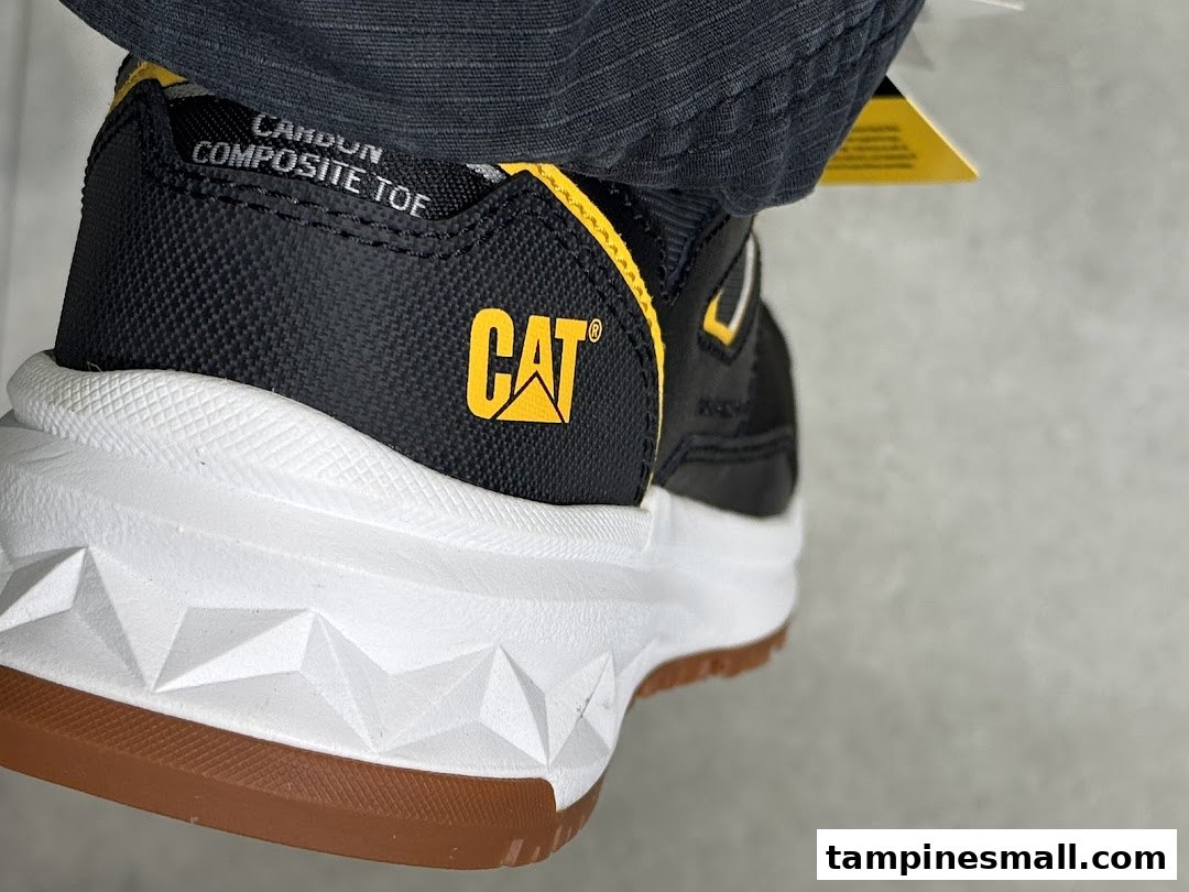 Close-up of a black and yellow CAT brand shoe with a white sole and 'COMPOSITE TOE' text.