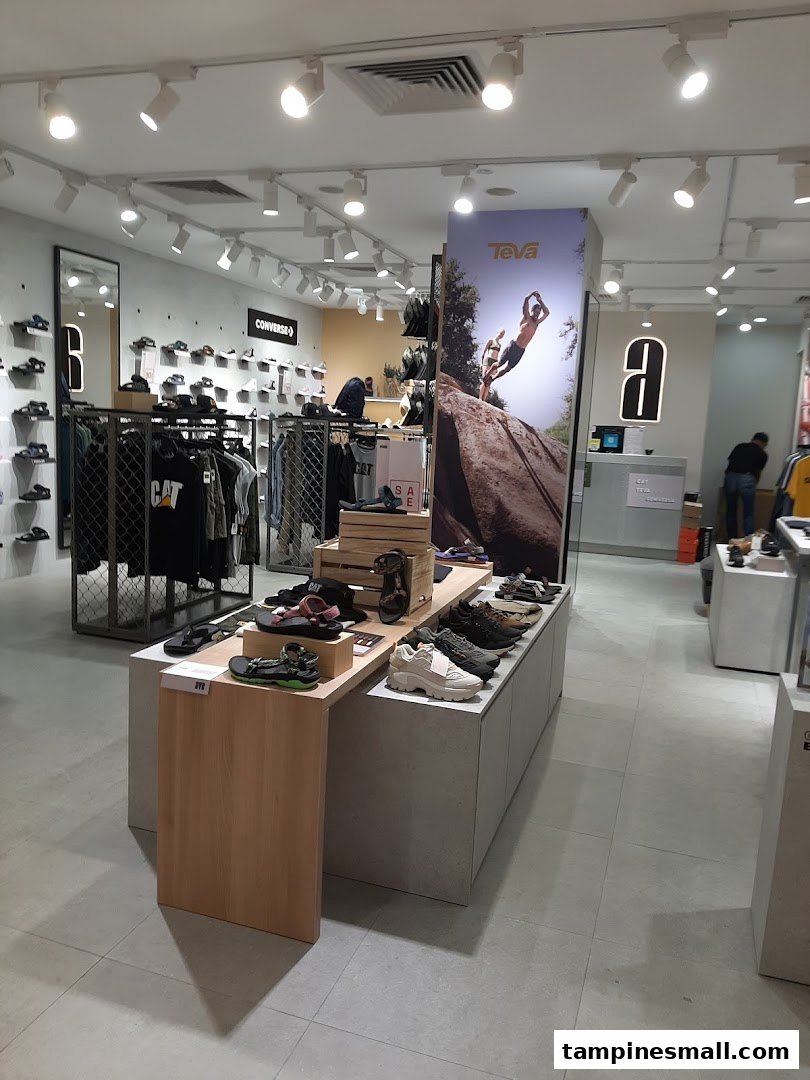 An interior view of a modern footwear and apparel store featuring brands like Converse, Teva, and CAT.