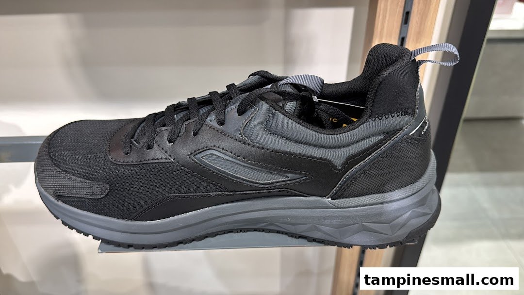 A black and grey athletic shoe displayed on a shelf in a retail store.