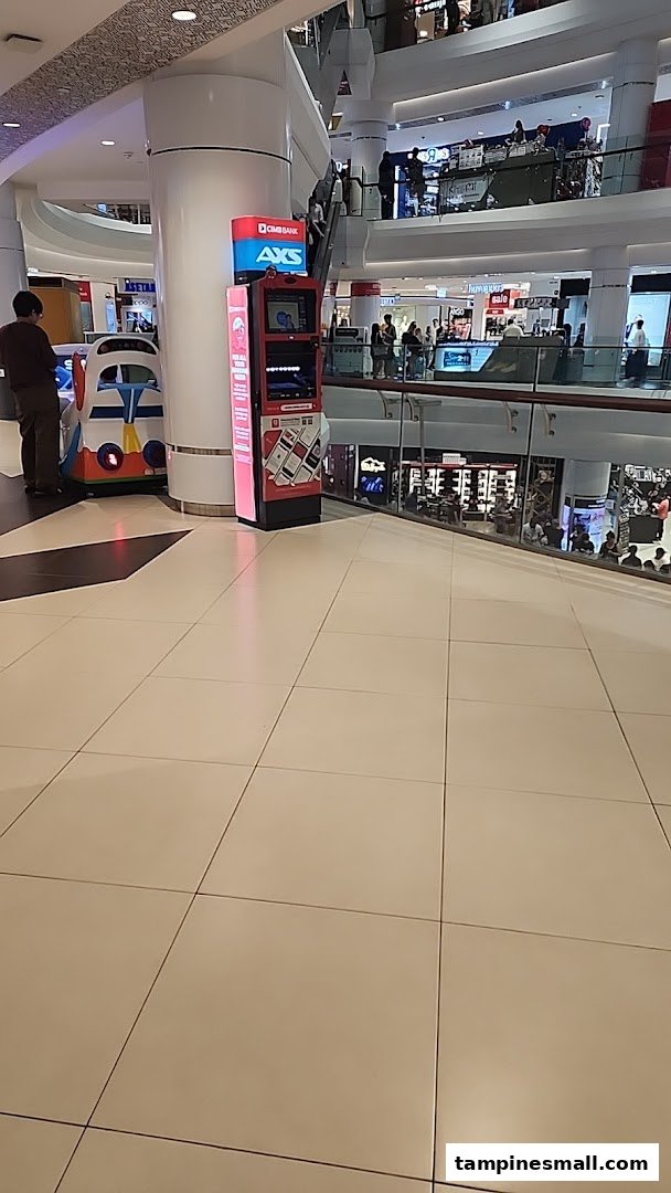 An AXS payment and service kiosk located within a bustling shopping mall.