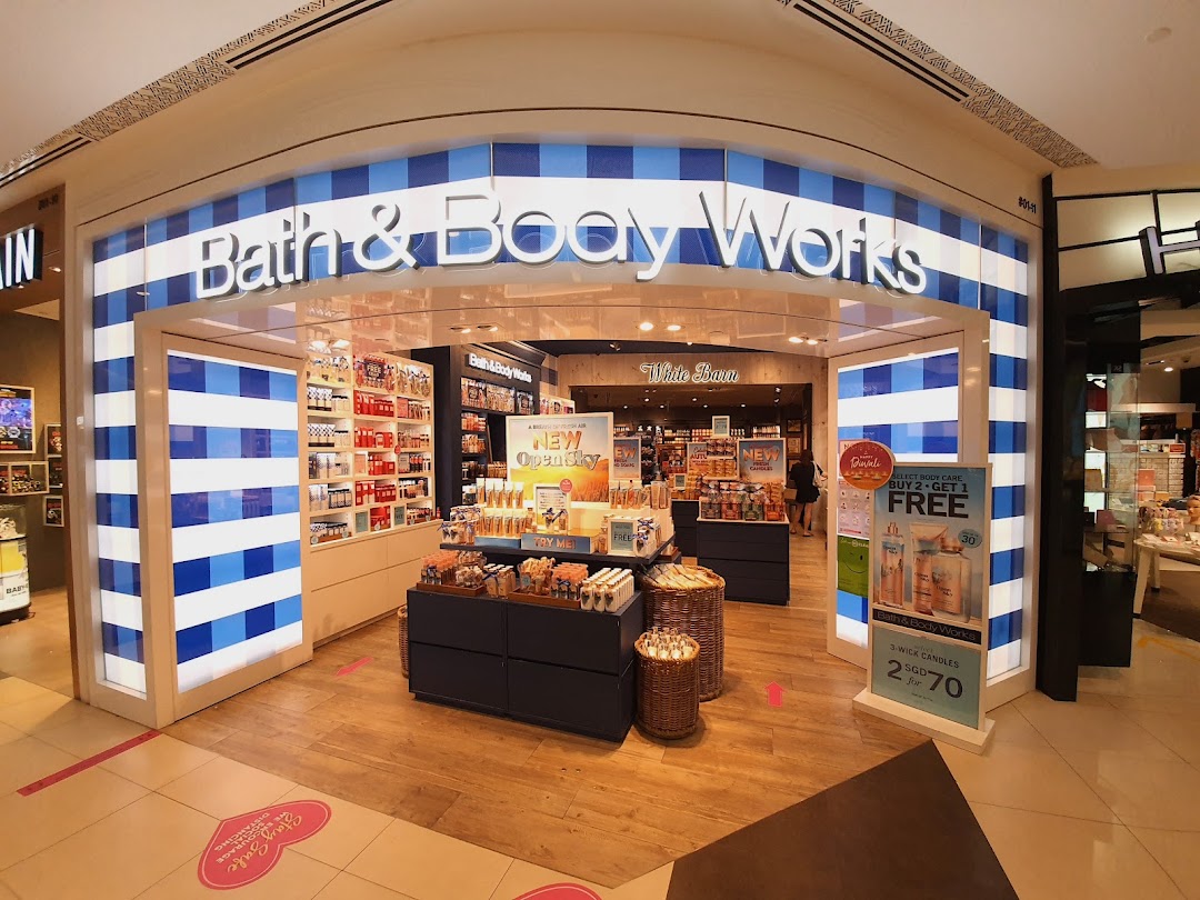 The vibrant storefront of Bath & Body Works, featuring its signature blue and white stripes and inviting product displays.
