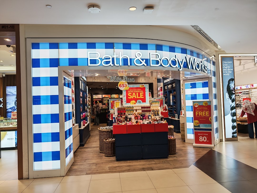 The Bath & Body Works shop front at Tampines Mall, featuring its iconic blue and white checkered design and prominent sale signs.