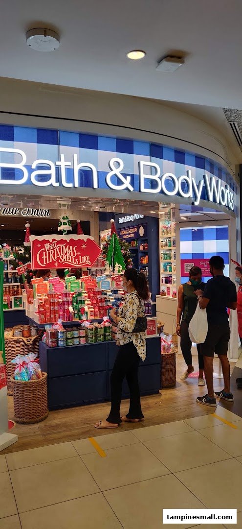 The Bath & Body Works shop entrance, featuring festive Christmas decorations and customers browsing products.