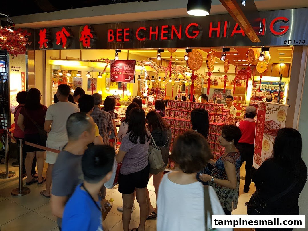 Bee Cheng Hiang shop front with customers queuing, decorated for Chinese New Year festivities.