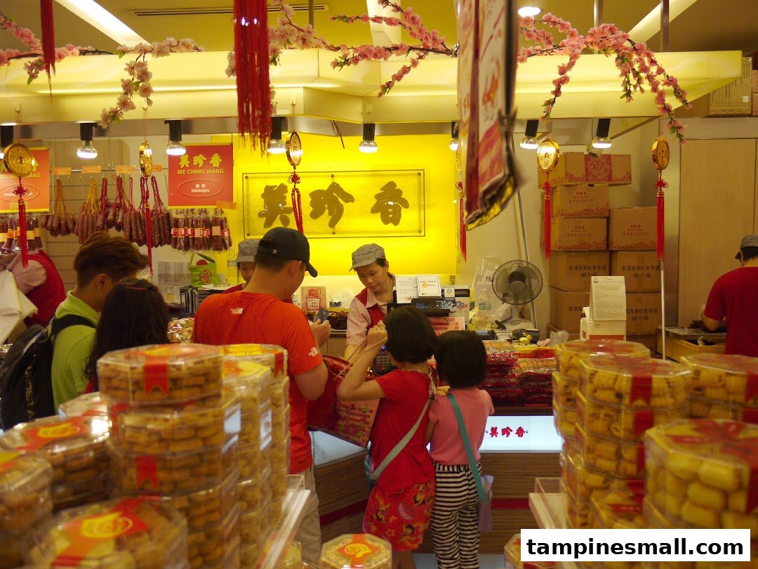 Customers and staff in a bustling Bee Cheng Hiang store, featuring traditional decorations and various products.