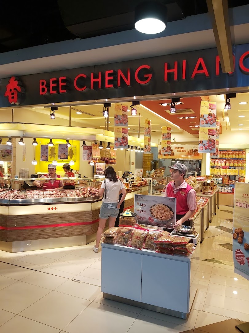 The Bee Cheng Hiang shop entrance features staff, customers, and a display of their famous bak kwa products.
