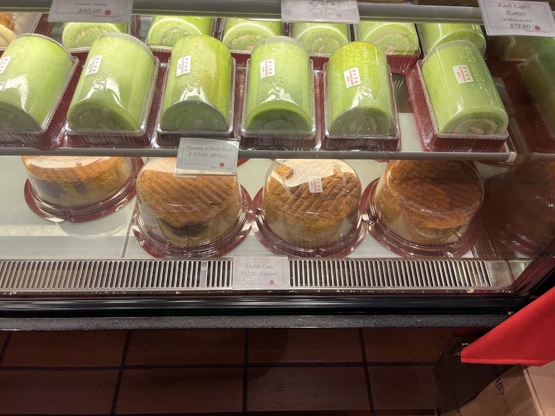 A vibrant display case showcasing a variety of freshly baked cakes and rolls at Bengawan Solo.