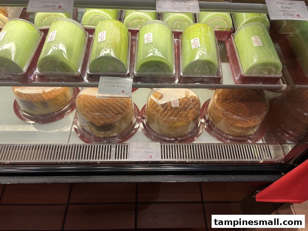 A vibrant display case showcasing a variety of freshly baked cakes and rolls at Bengawan Solo.