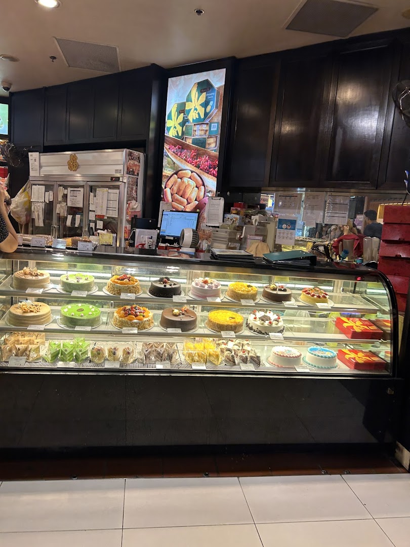A vibrant display case filled with various cakes and pastries inside Bengawan Solo bakery.