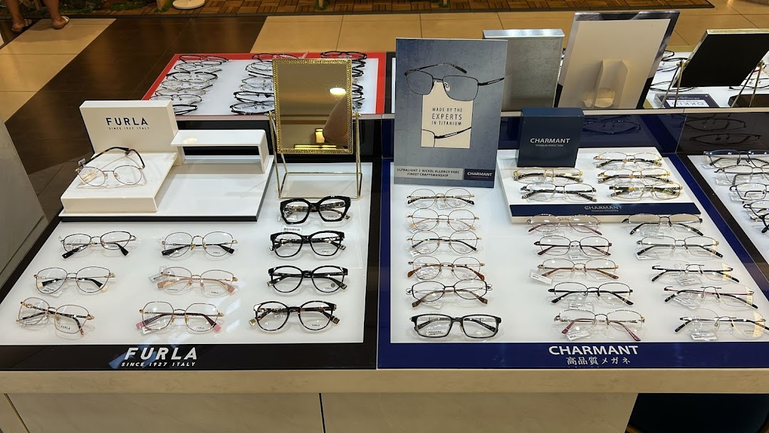 A display of various stylish eyeglasses from brands like Furla and Charmant inside an optical shop.