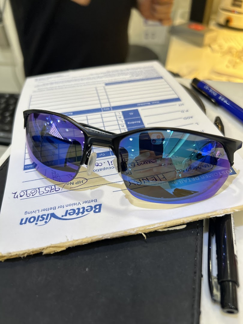 A pair of stylish blue-tinted sunglasses rests on a Better Vision customer form.