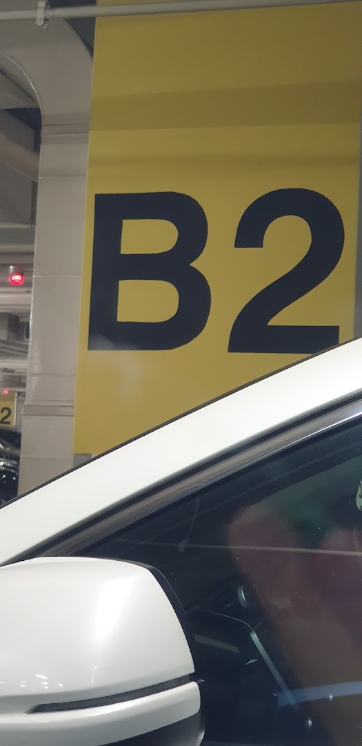 A large yellow sign indicating 'B2' in a parking deck, with a white car visible.