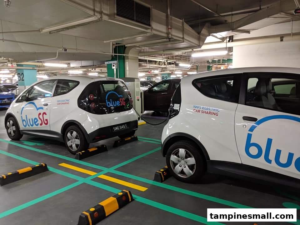 Two BlueSG electric car-sharing vehicles are parked and charging in a mall's underground car park.