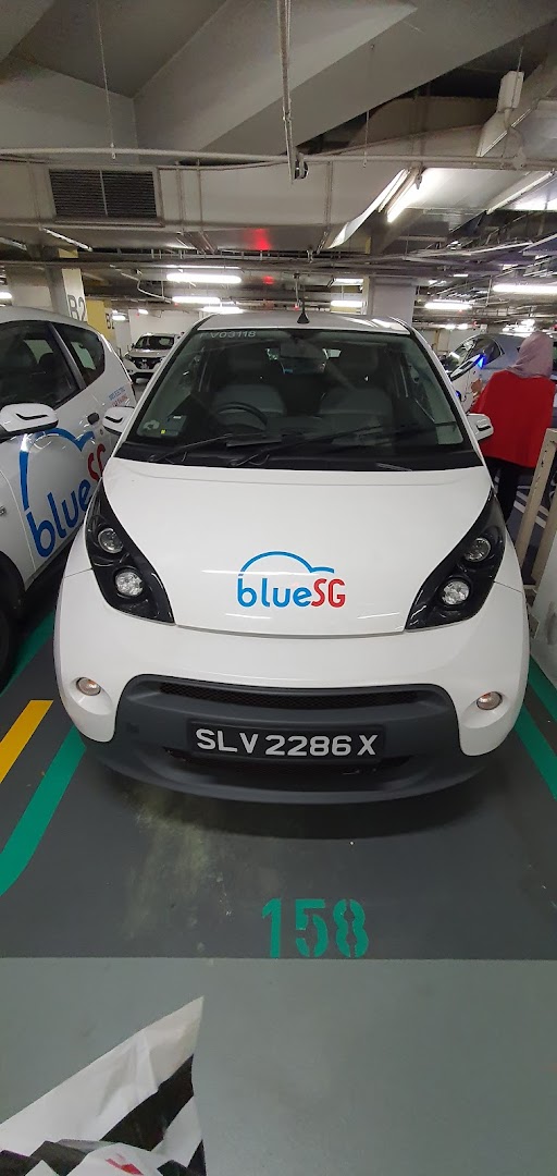 A white BlueSG electric car parked in an underground parking lot at Tampines Mall.