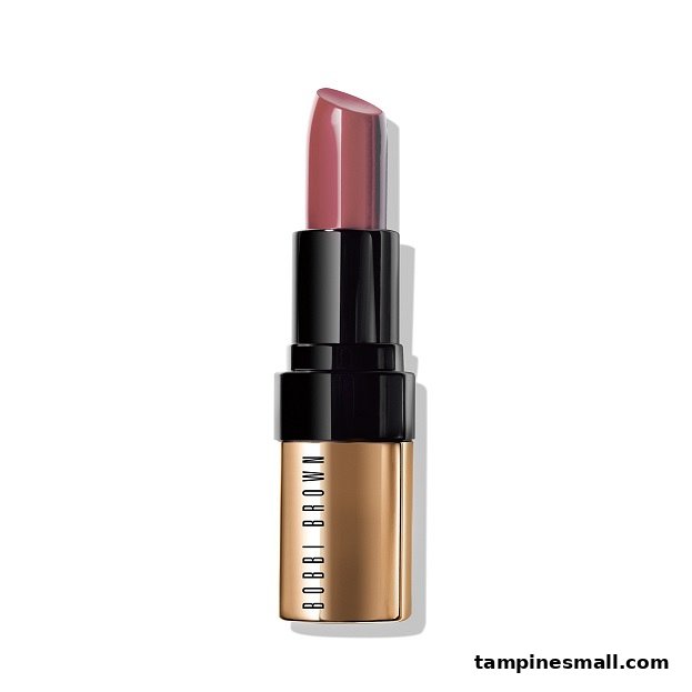 A close-up of a Bobbi Brown lipstick in a rose shade with elegant gold and black packaging.