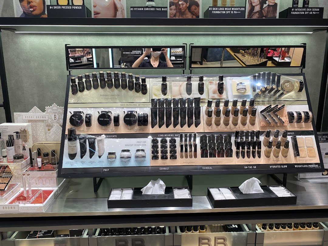 A well-lit Bobbi Brown makeup counter displaying various foundation, powder, and skincare products.