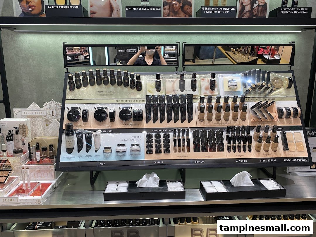 A well-lit Bobbi Brown makeup counter displaying various foundation, powder, and skincare products.