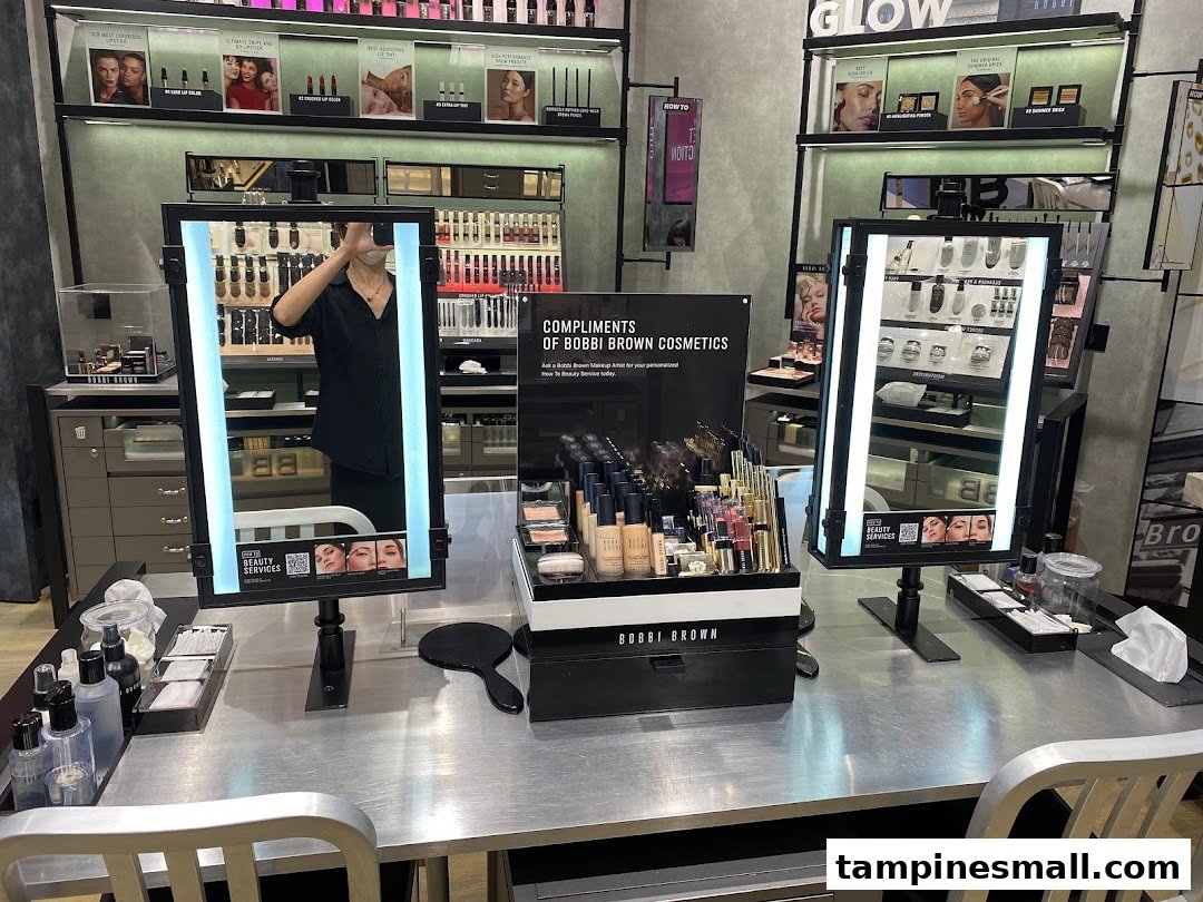 A well-lit Bobbi Brown makeup counter featuring a wide array of cosmetics, mirrors, and beauty services setup.