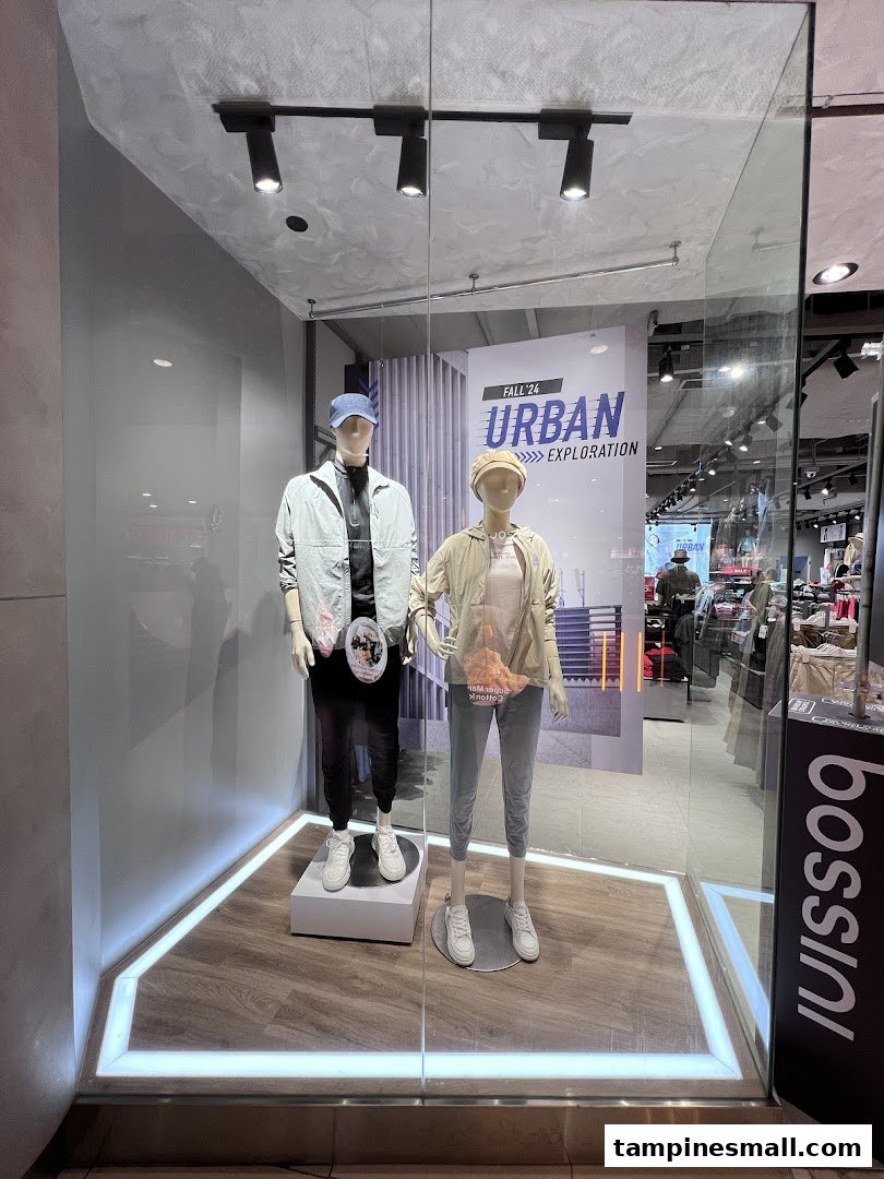 A shop window display featuring two mannequins dressed in casual urban wear, with the 'bossini' logo visible.