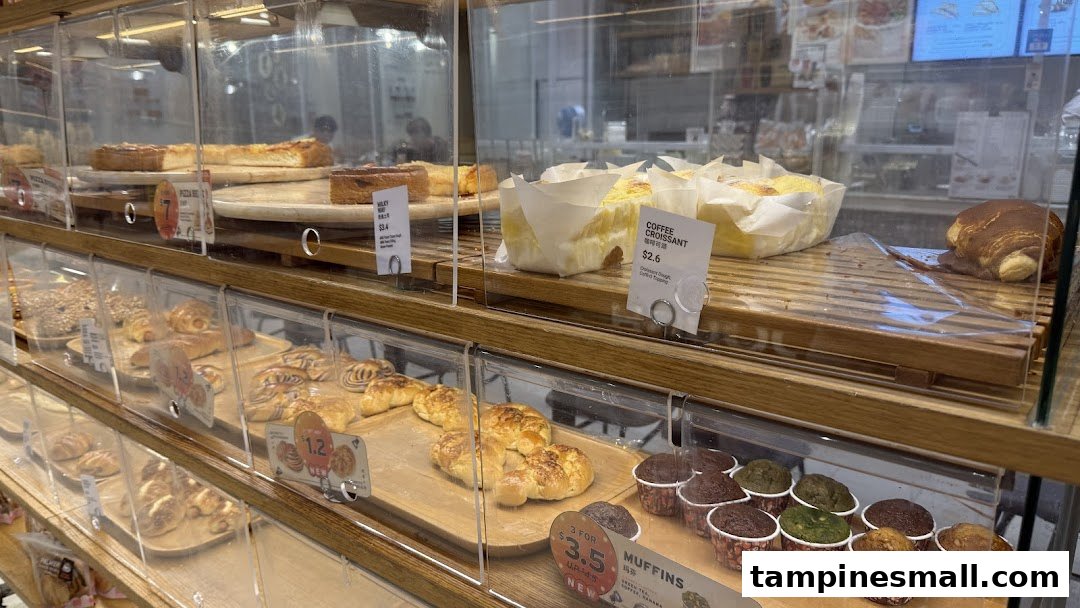 A vibrant display case showcasing a variety of freshly baked pastries, muffins, and cakes at BreadTalk.