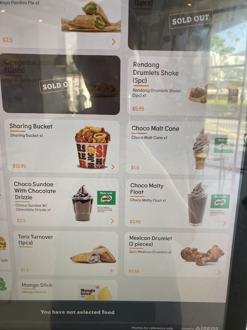 A digital menu board displaying various food and dessert items with prices, including some 'SOLD OUT' options.