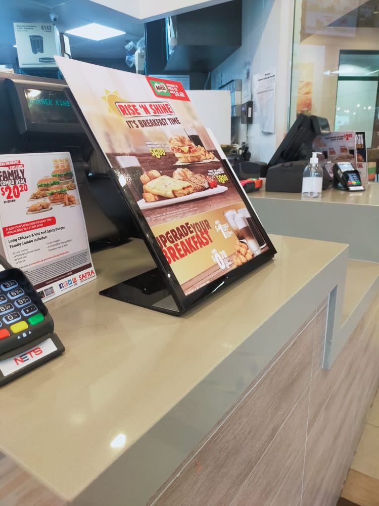 A close-up of Burger King's counter featuring breakfast and family combo promotional menus.
