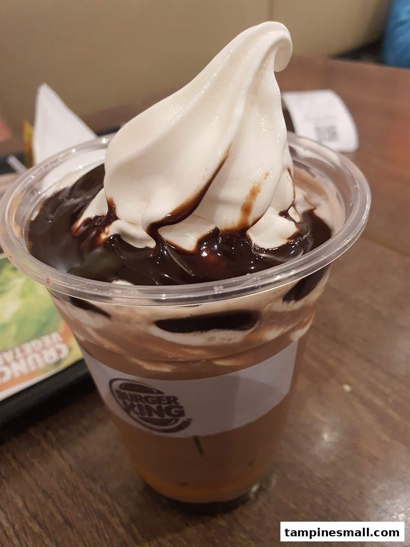 A close-up of a Burger King dessert drink featuring soft-serve ice cream and rich chocolate syrup.
