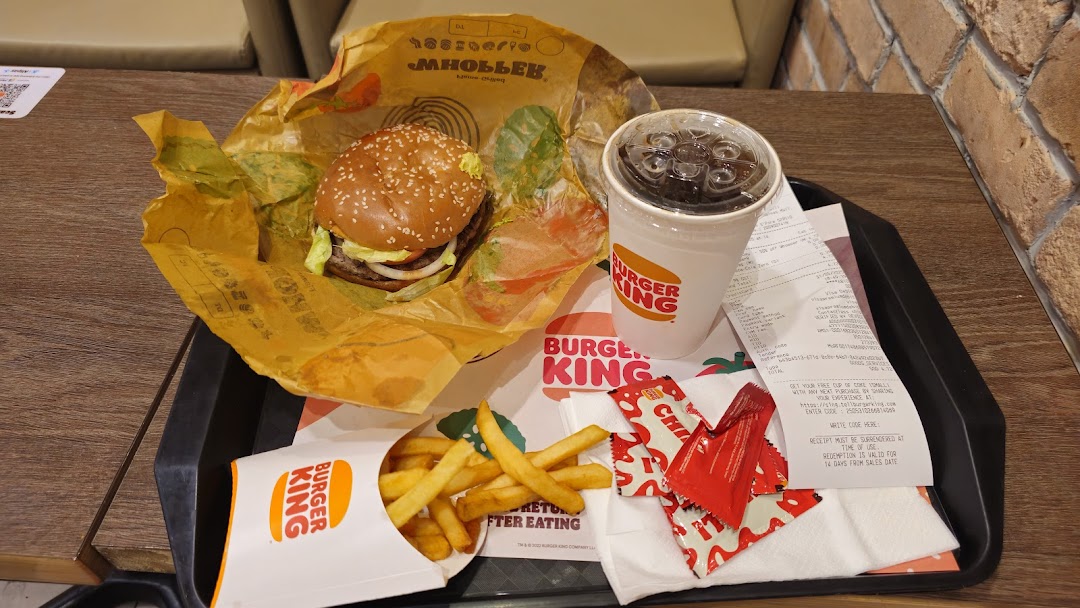 A classic Burger King meal featuring a burger, fries, and a drink on a tray.