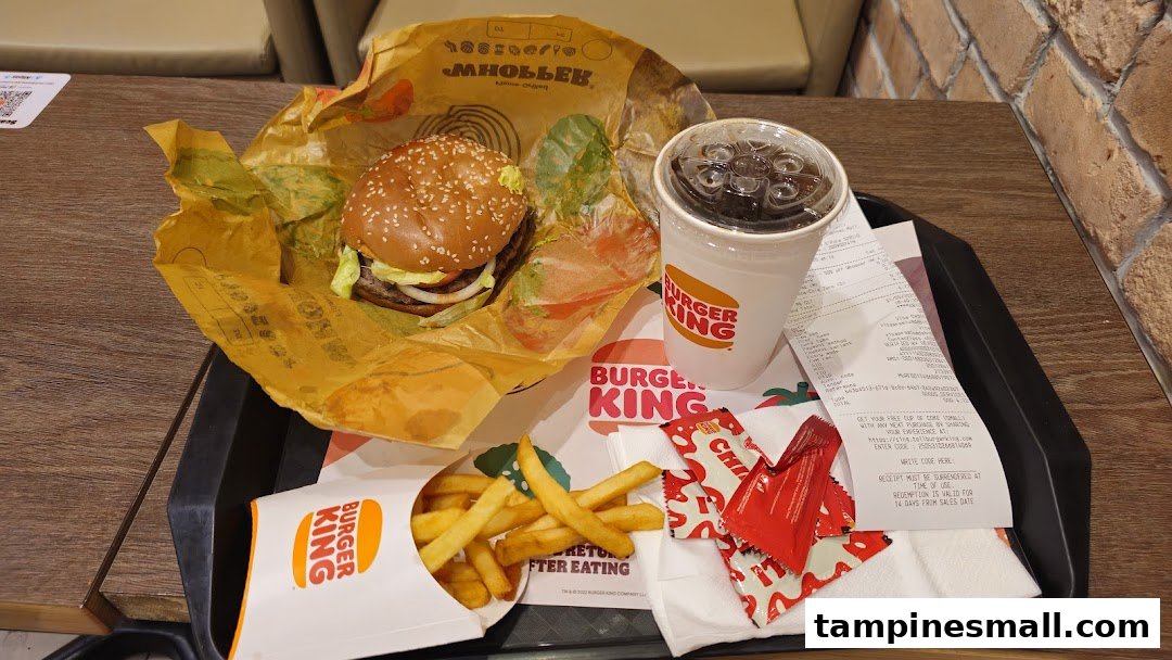 A classic Burger King meal featuring a burger, fries, and a drink on a tray.