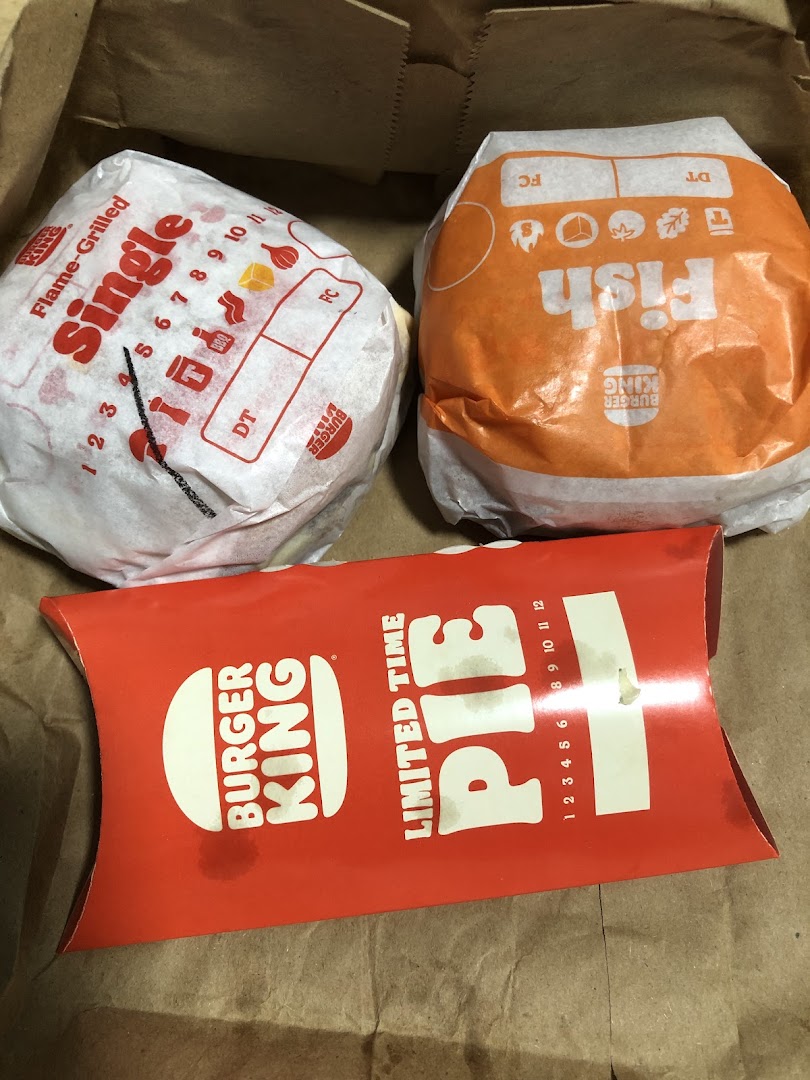 Burger King Flame-Grilled Single, Fish burger, and a Limited Time Pie in a paper bag.
